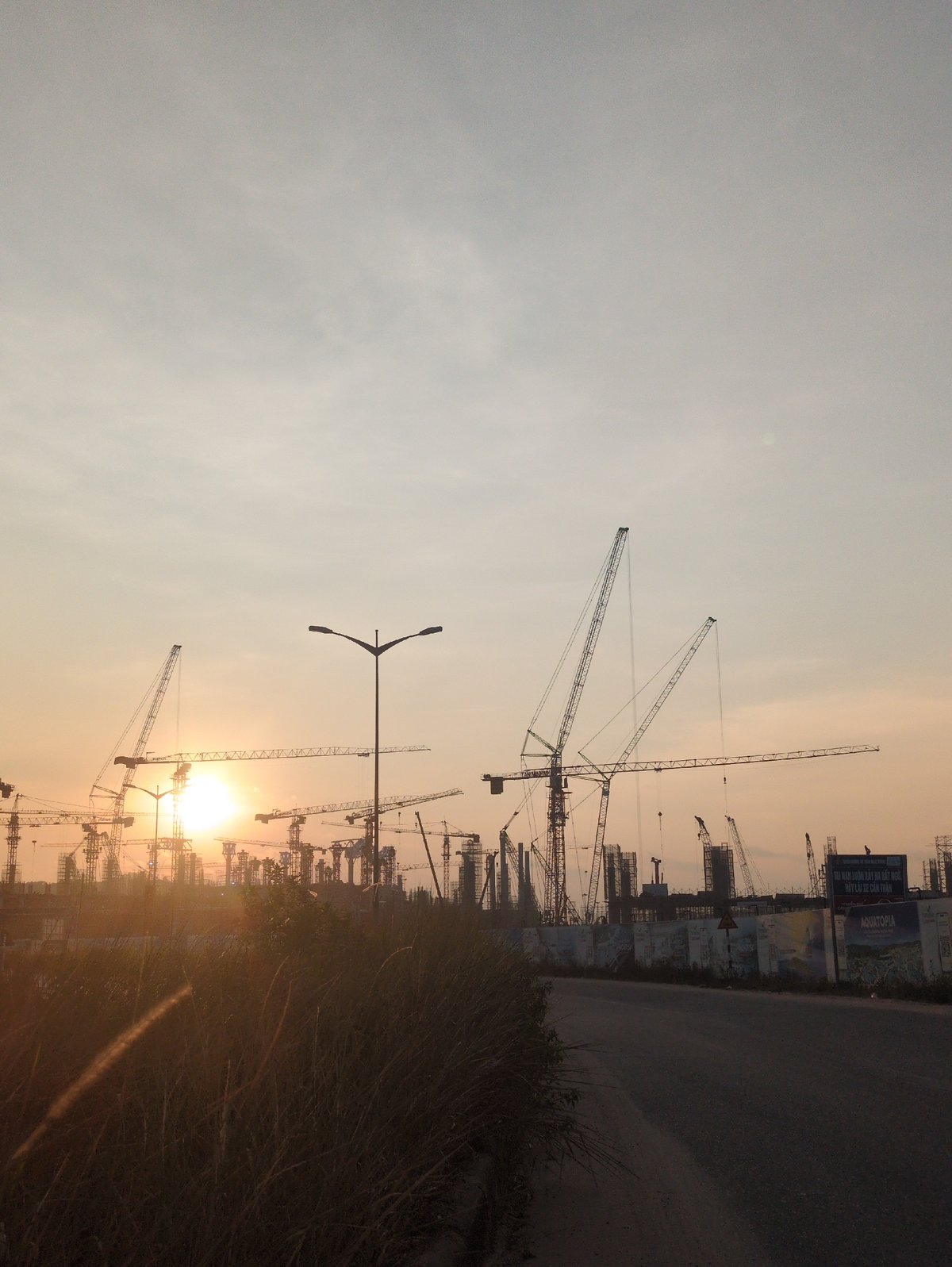 Construction cranes silhouetted against sunrise in Phú Quốc, Vietnam