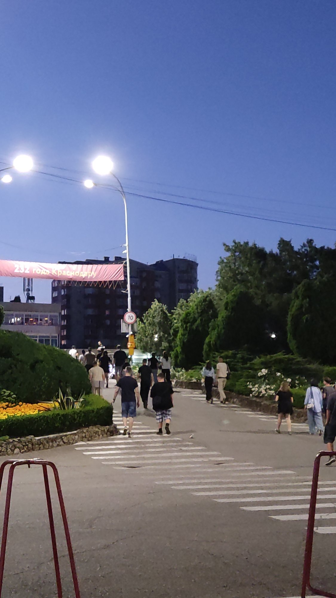 Krasnodar at dusk: waterfront, amusement rides, and an upside-down house