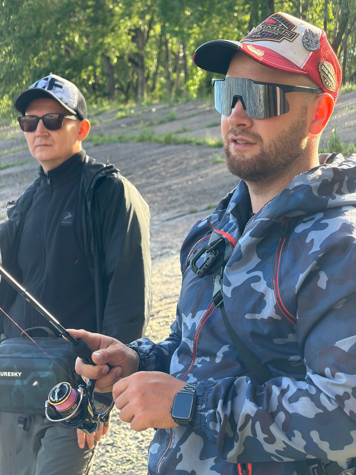 Two men fishing from concrete embankment in Chaikovsky