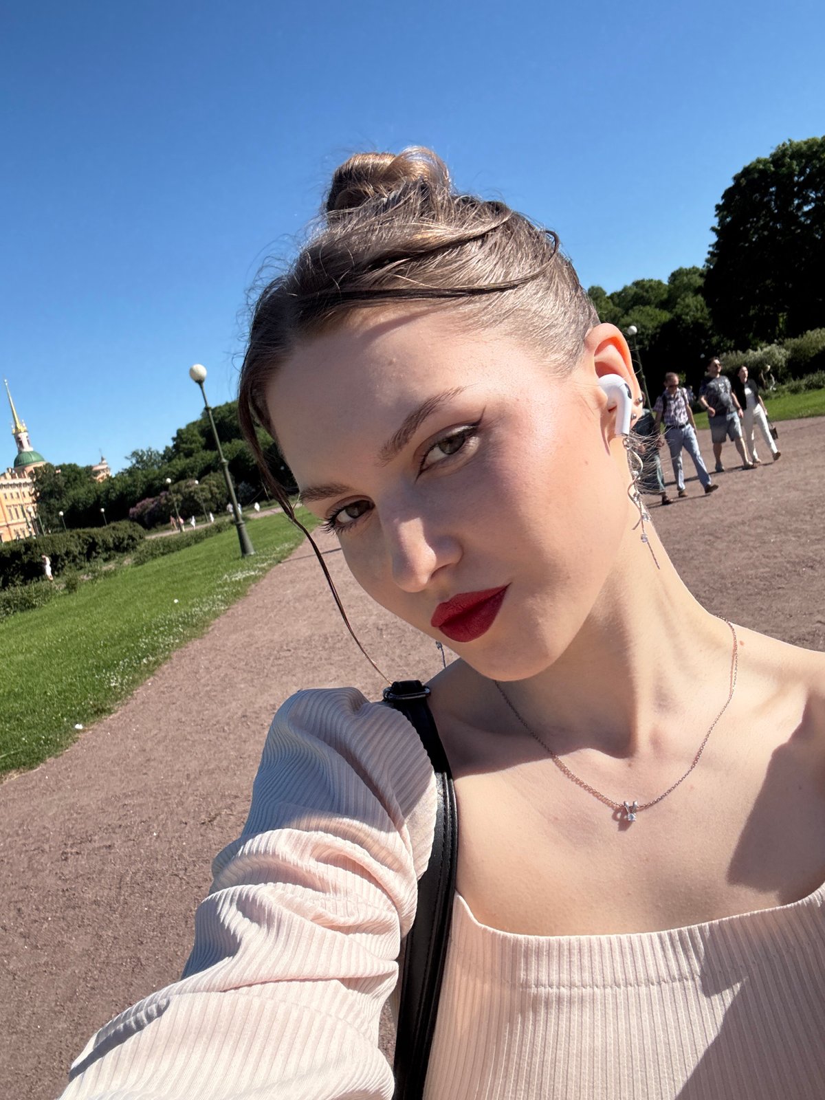 Tourist documents sunny afternoon walk through historic Saint Petersburg landmarks