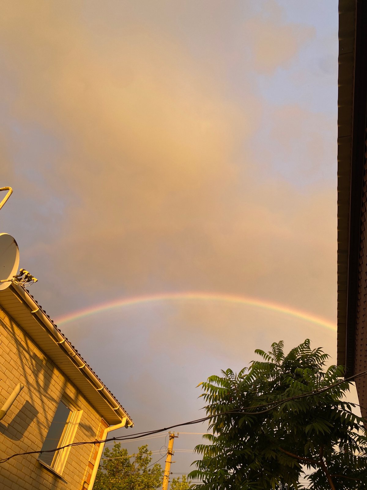 Double rainbow arcs across a golden late-afternoon sky