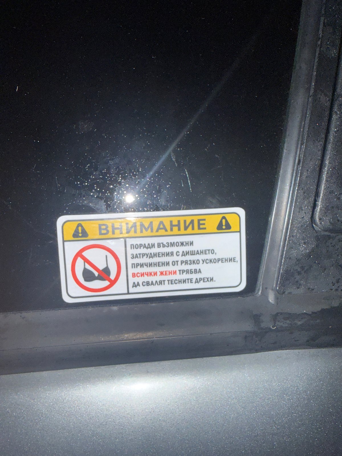 Alfa Romeo parked at night in Burgas, offensive sticker on display