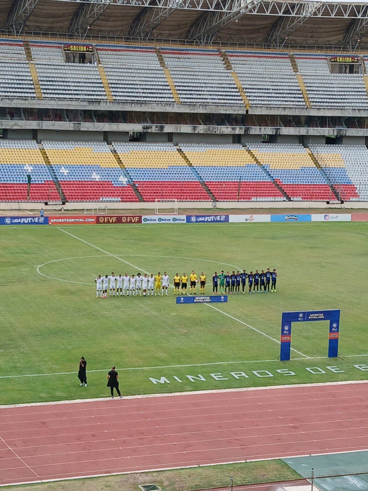 Soccer match held at colorful stadium with empty stands