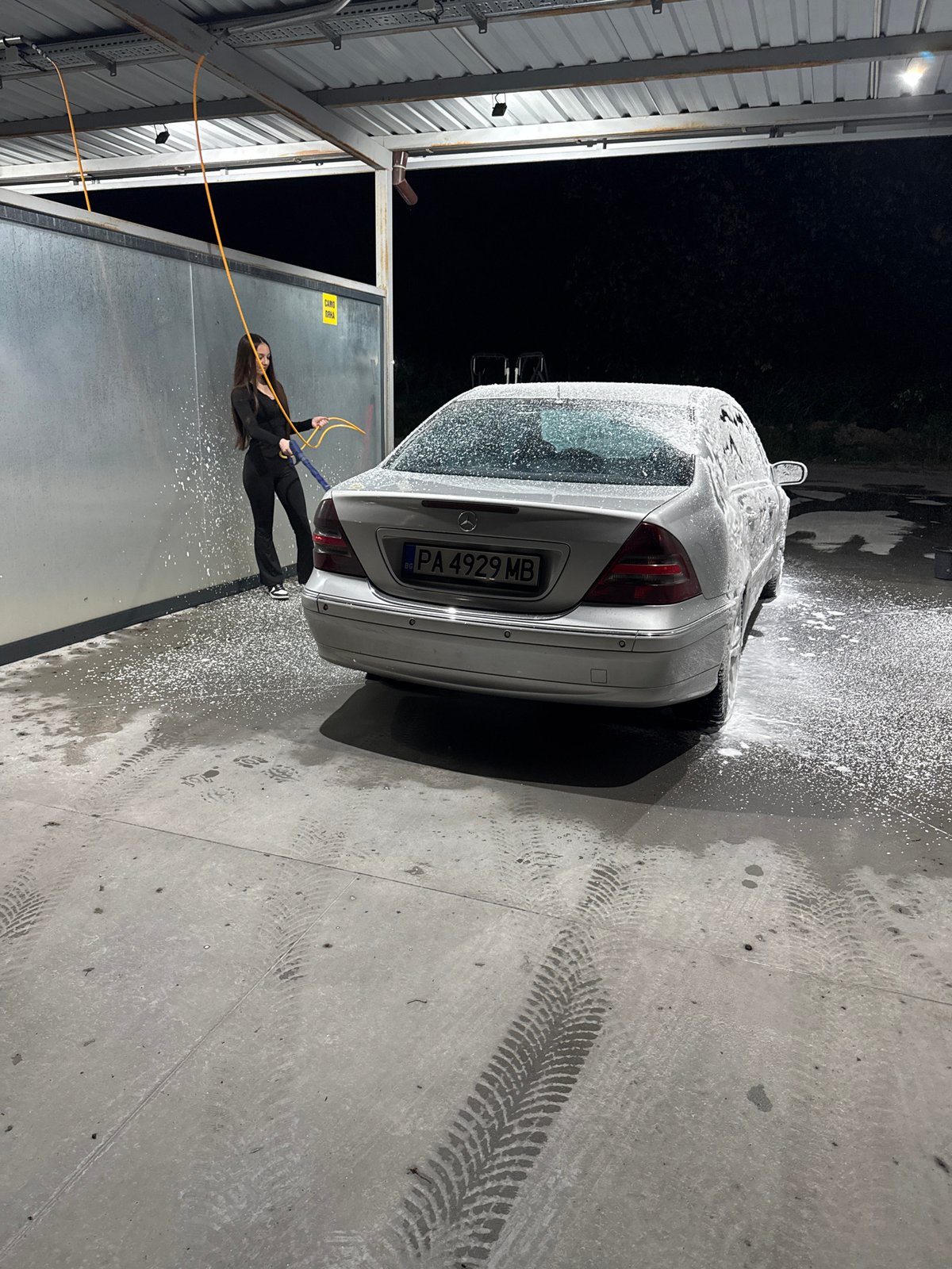 Woman washes silver Mercedes at car wash in Plovdiv