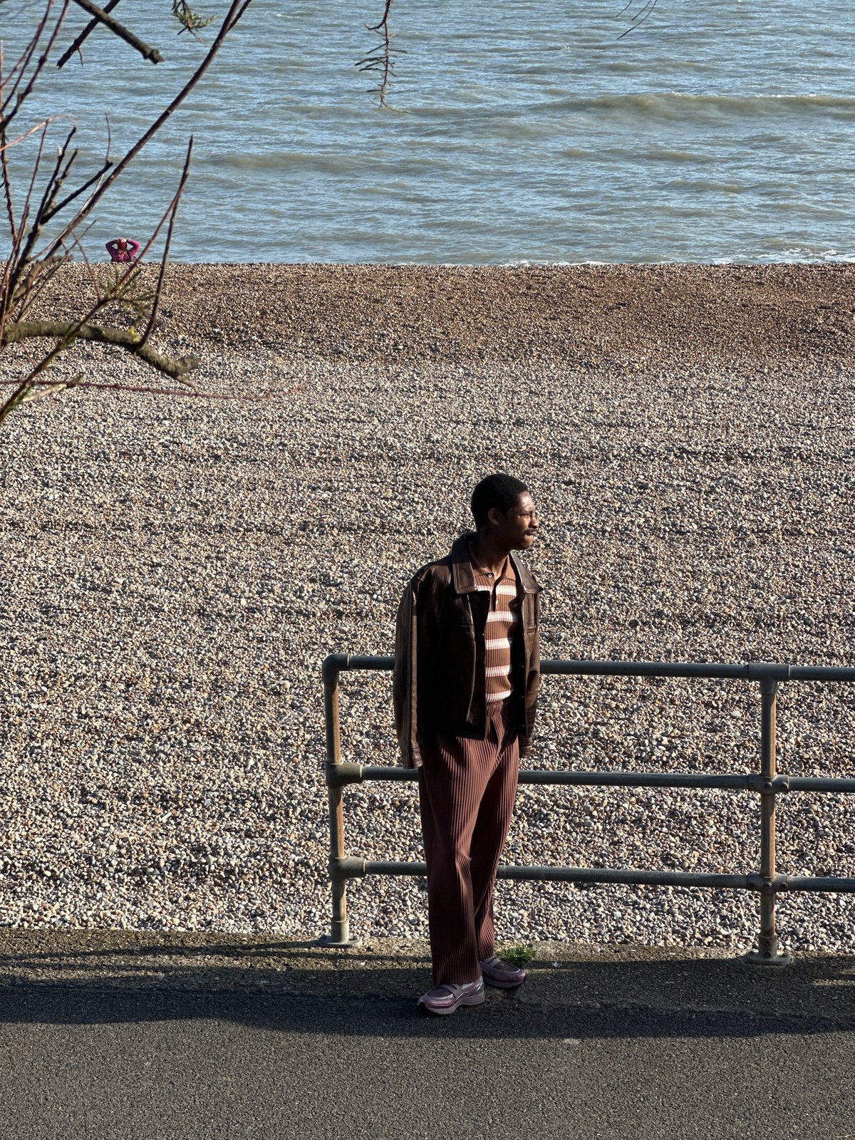 Man lies across beach railing in Folkestone district