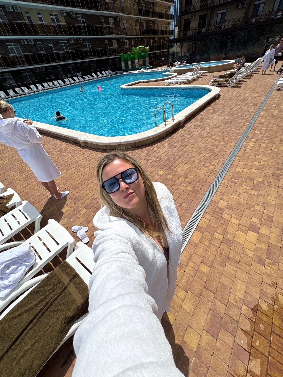 Woman enjoys morning poolside relaxation at Anapa resort