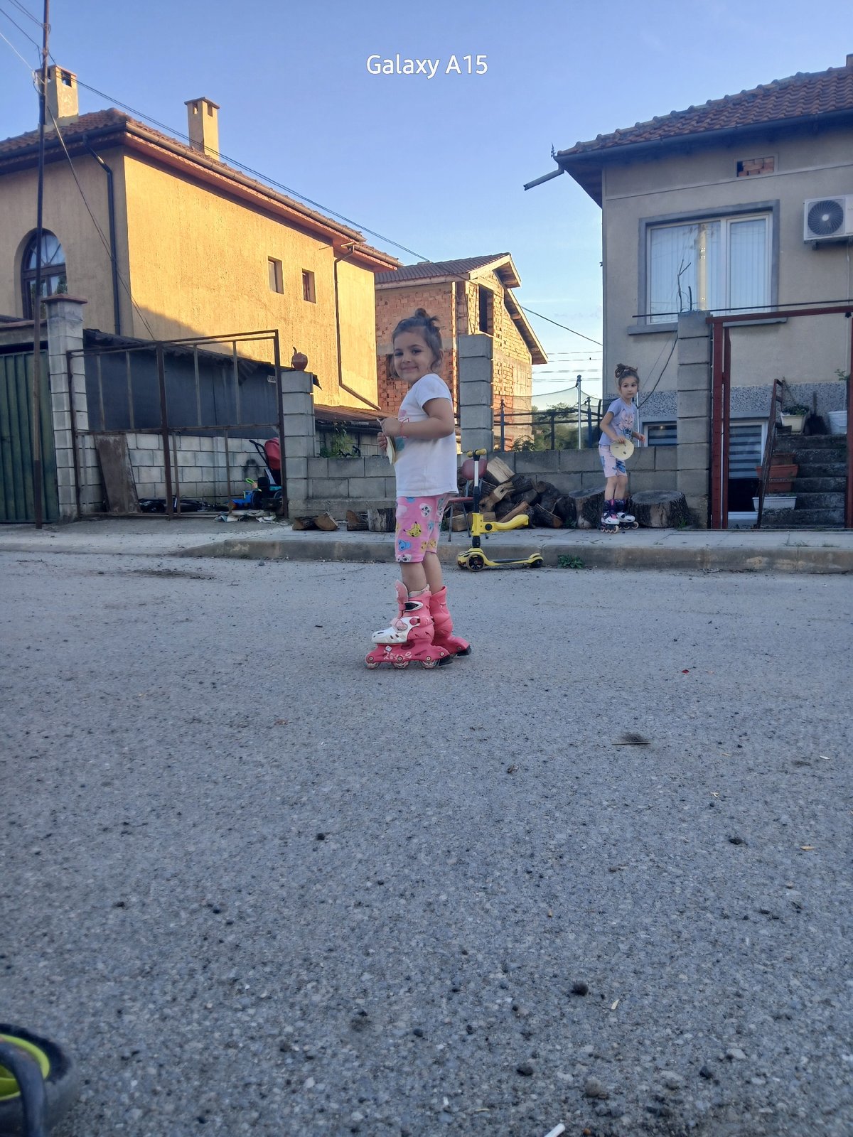 Children play with roller skates, toy horse in Bulgarian village