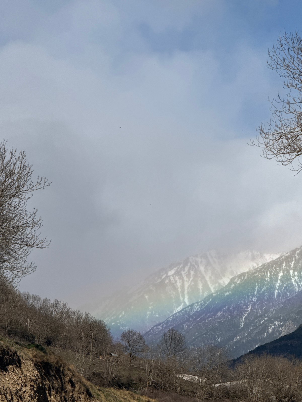 Rainbow appears over hillside in Sahún, Spain mountains