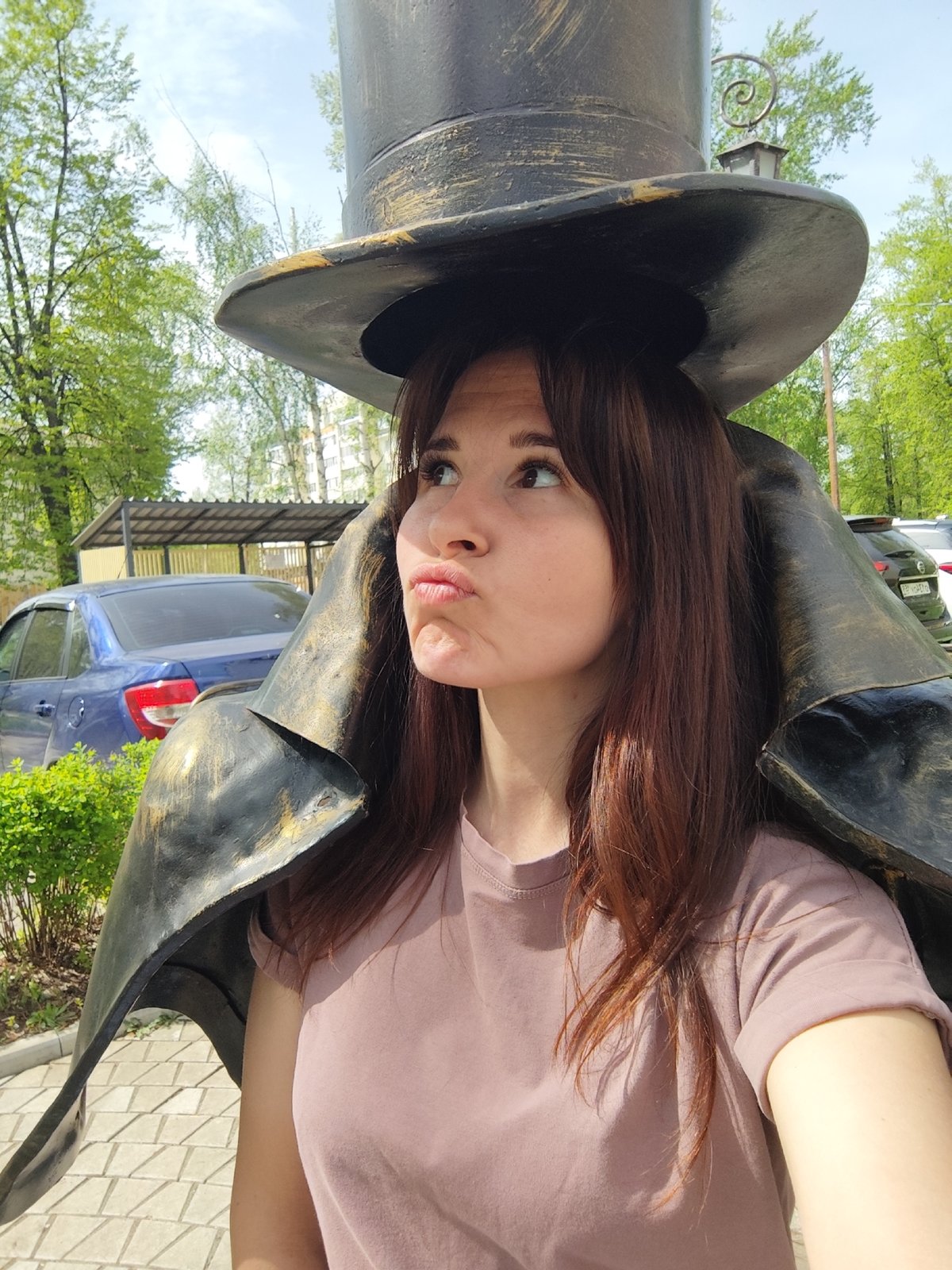Tourists pose with top hat statue in Chaikovsky, Russia