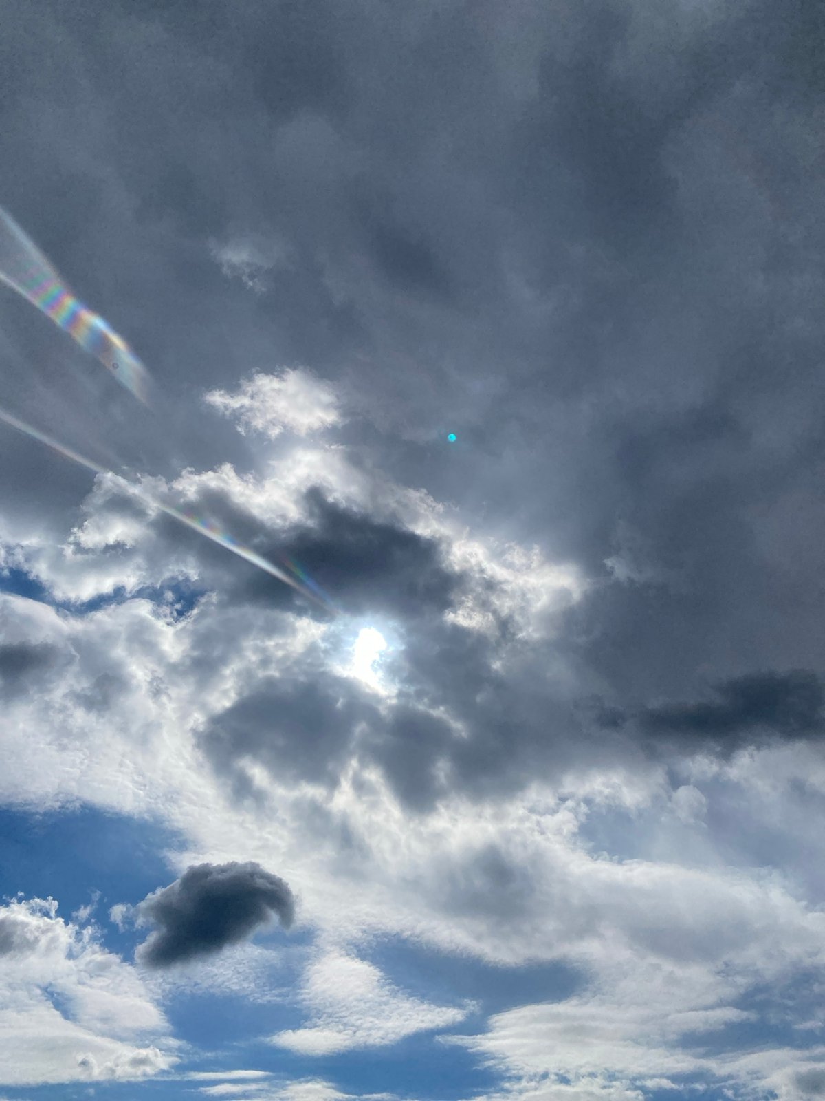 Woman vapes while gazing at cloudy sky