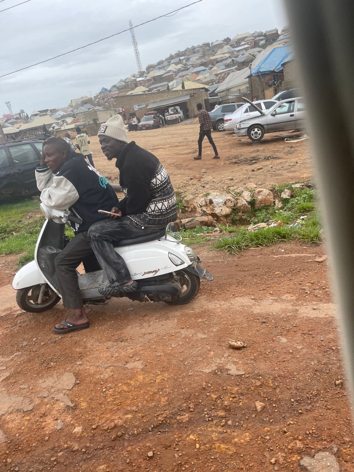 Street life and traffic along a busy Jos corridor