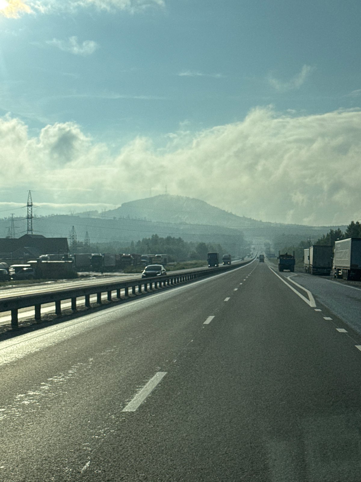 Hazy highway stretching through Revda under an overcast sky.