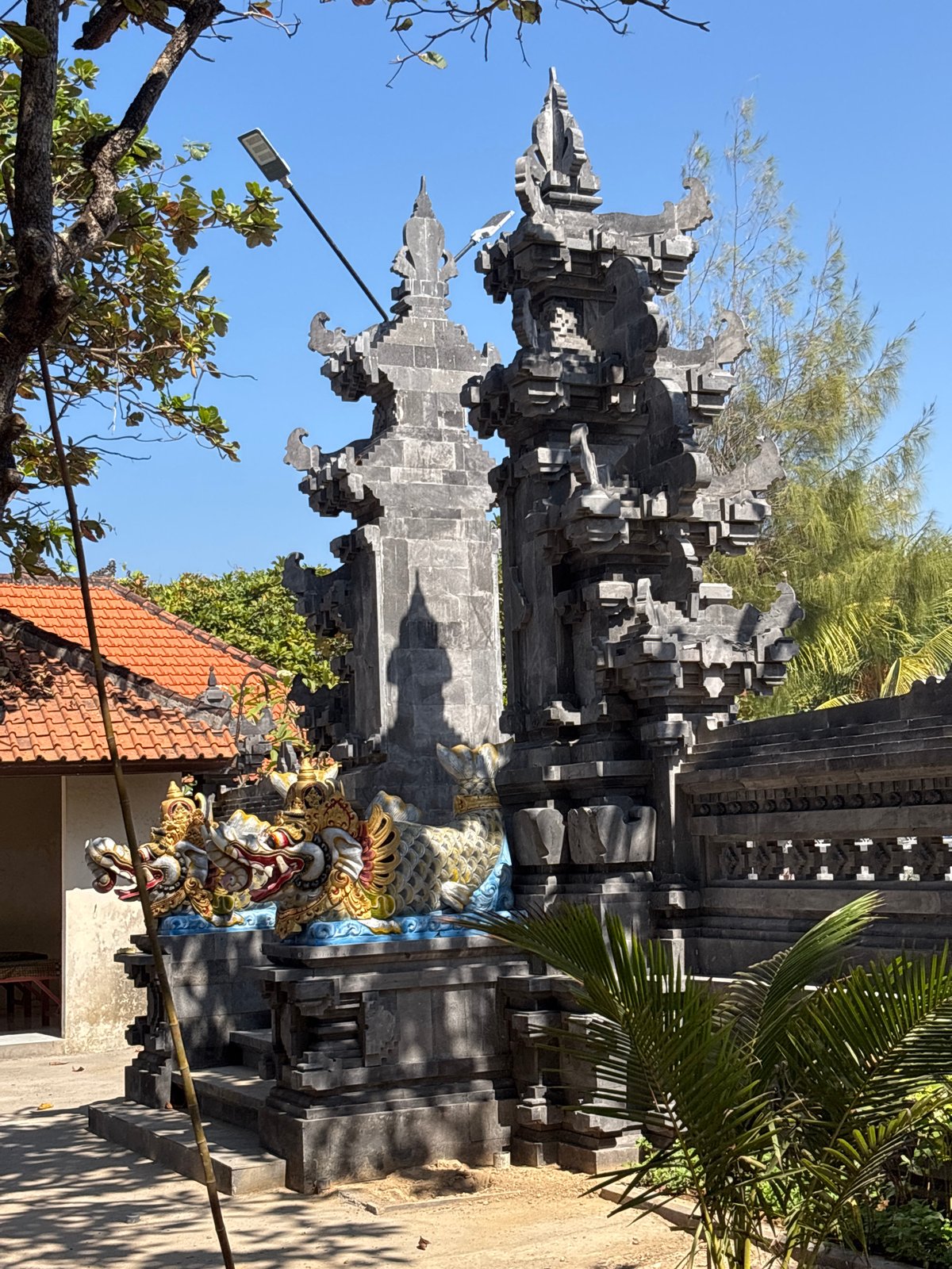 South Bali beachfront life around a carved Balinese gateway