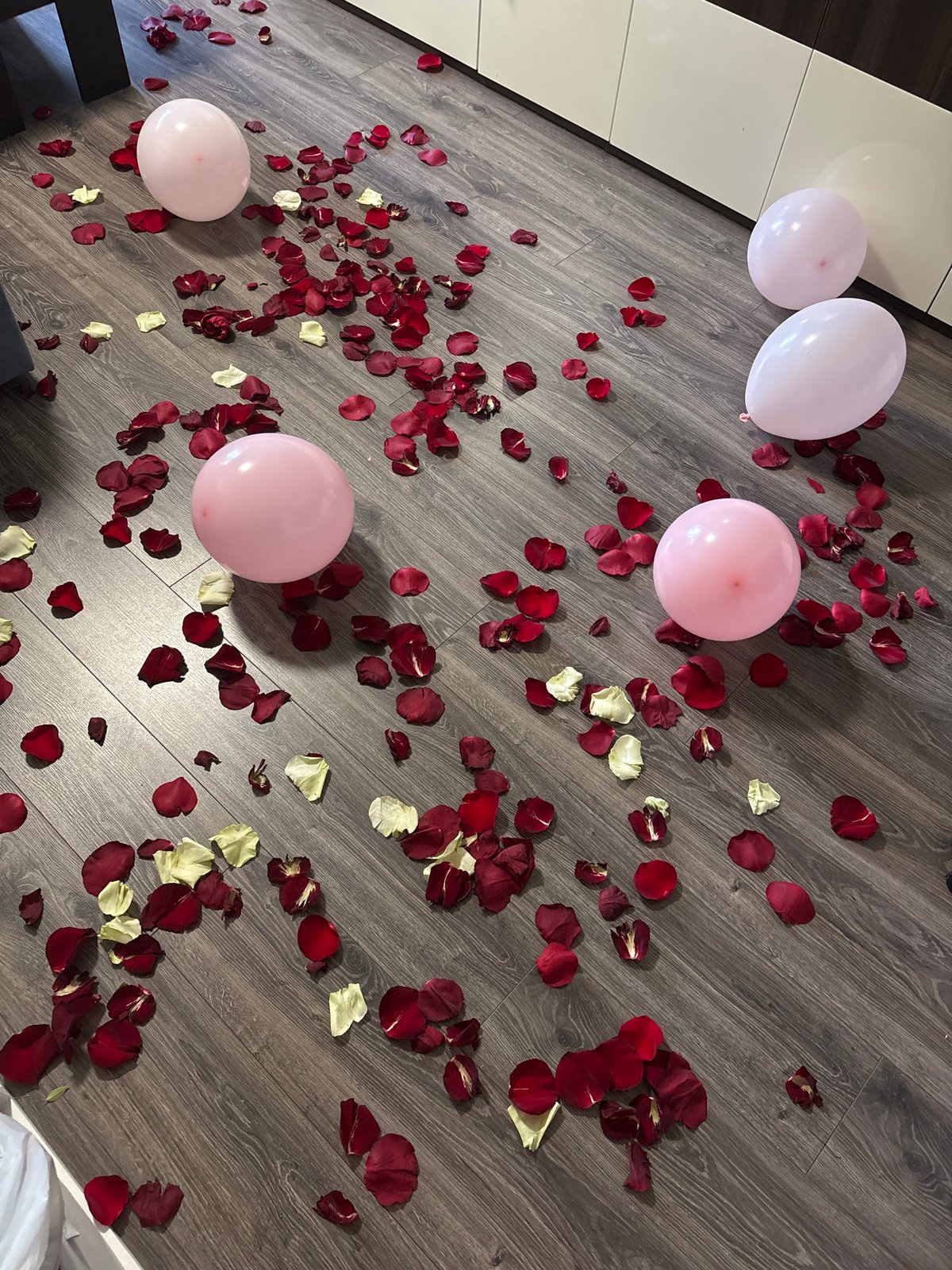 Rose petals, birthday cake, and balloons for a morning celebration