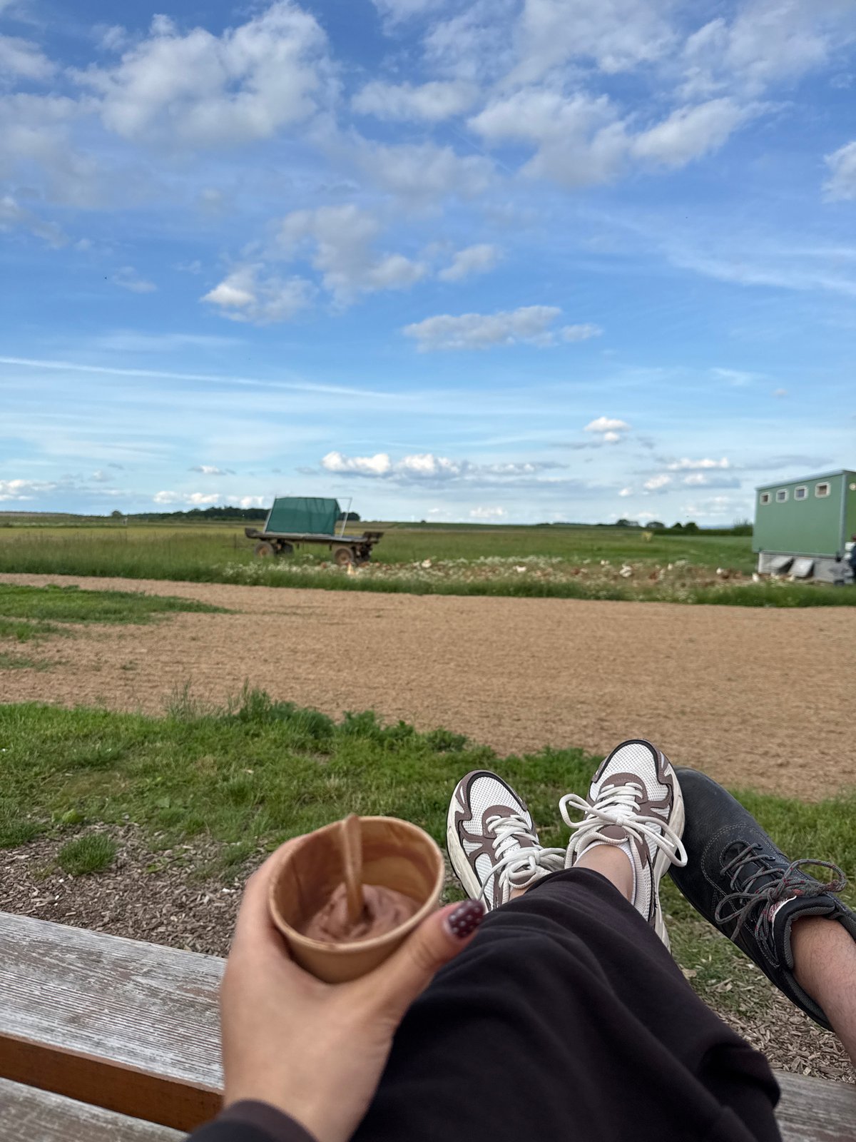 Two people share bench moment in Bruchköbel landscape