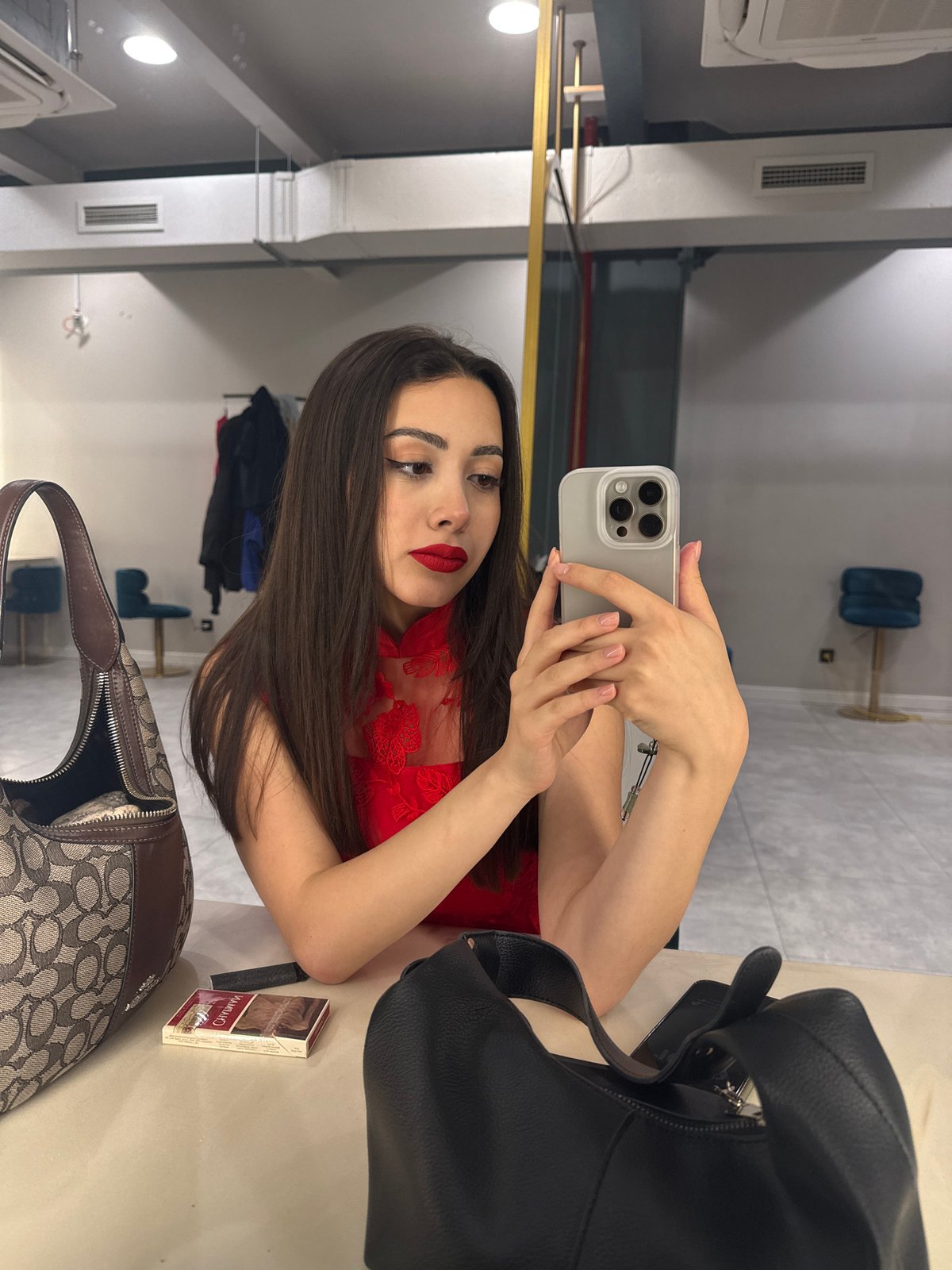 Woman takes selfie in red dress at Yerevan indoor location