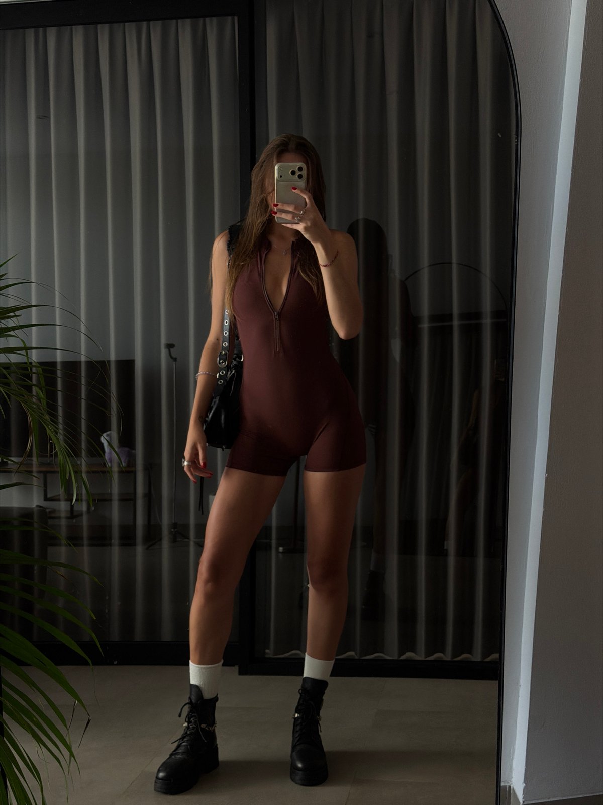 Woman takes mirror selfie in brown romper in Canggu