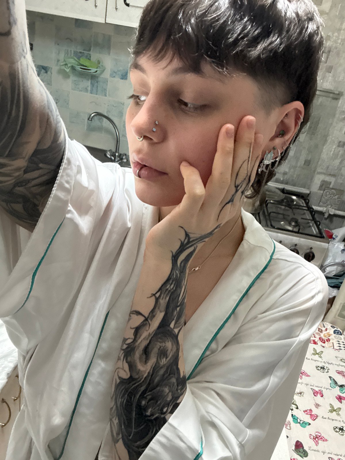 Tattooed individual photographed in white robe inside Saint Petersburg residence
