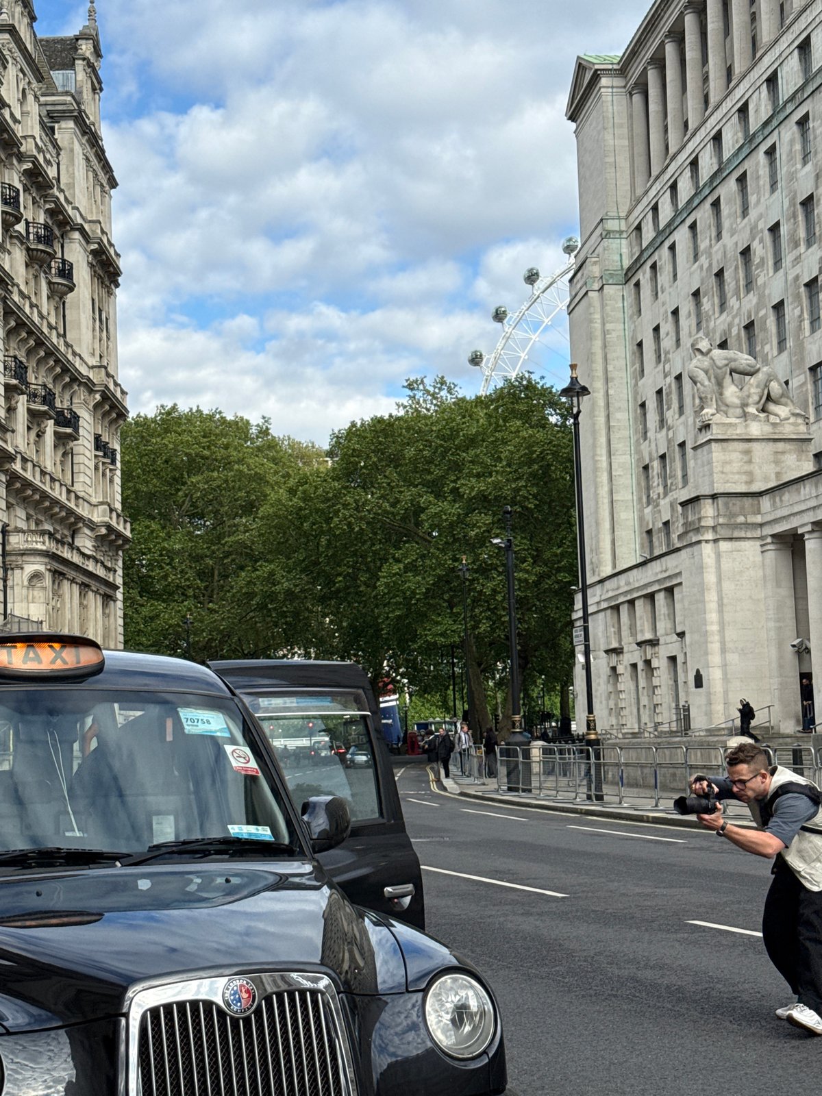 Photographer captures images beside London taxi near London Eye