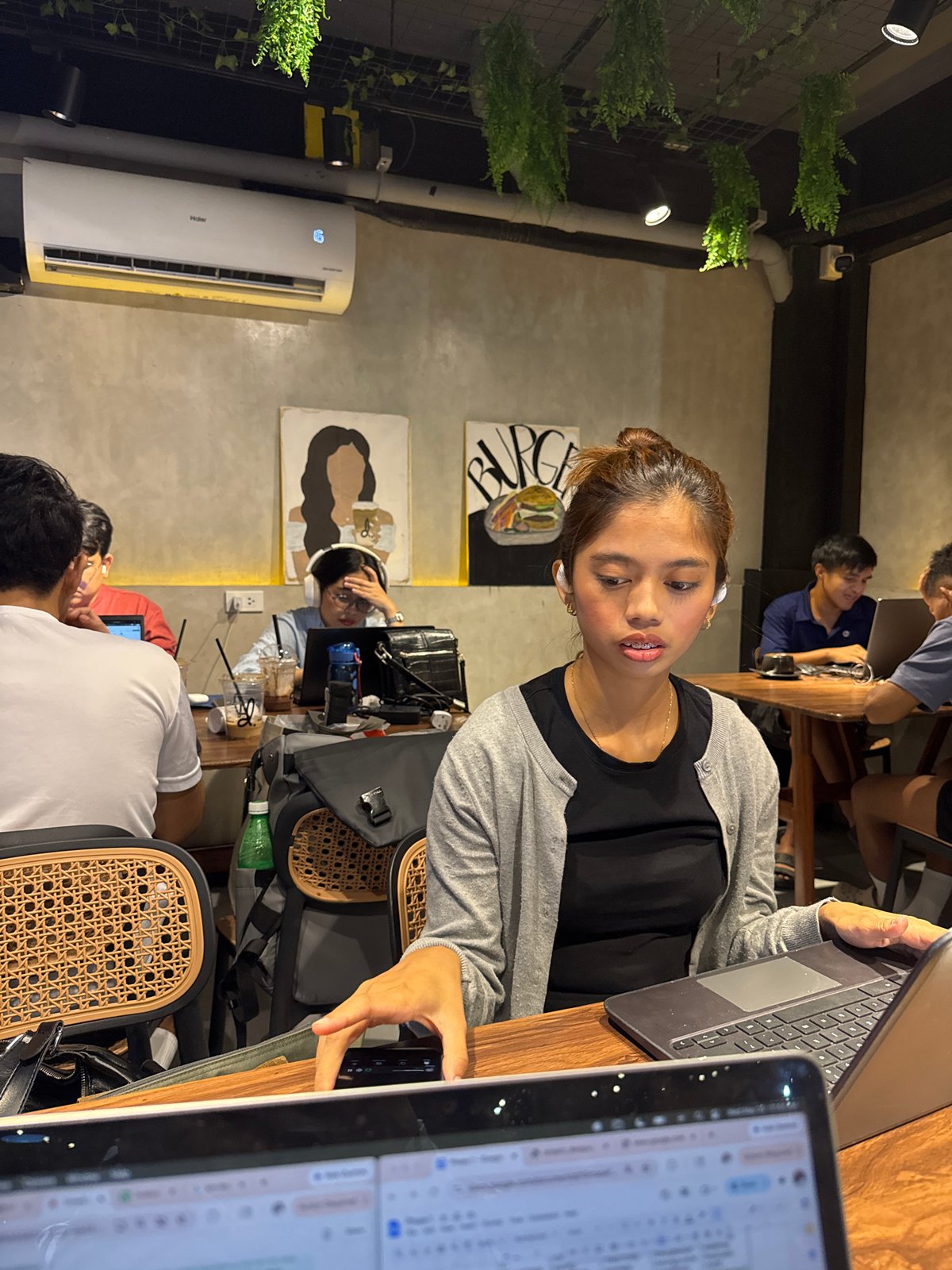 Woman works on laptop at busy Davao City café