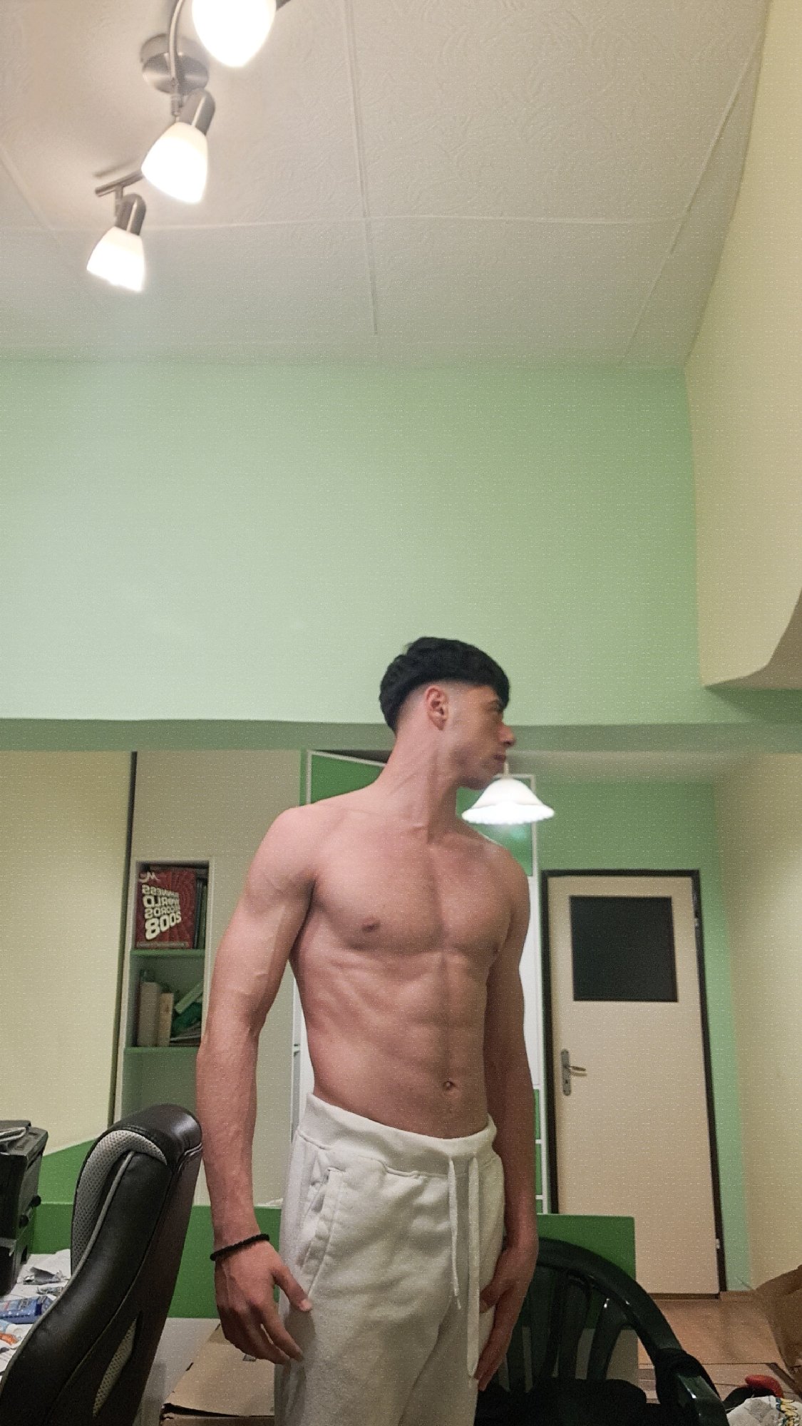 Man poses shirtless indoors in Burgas, Bulgaria