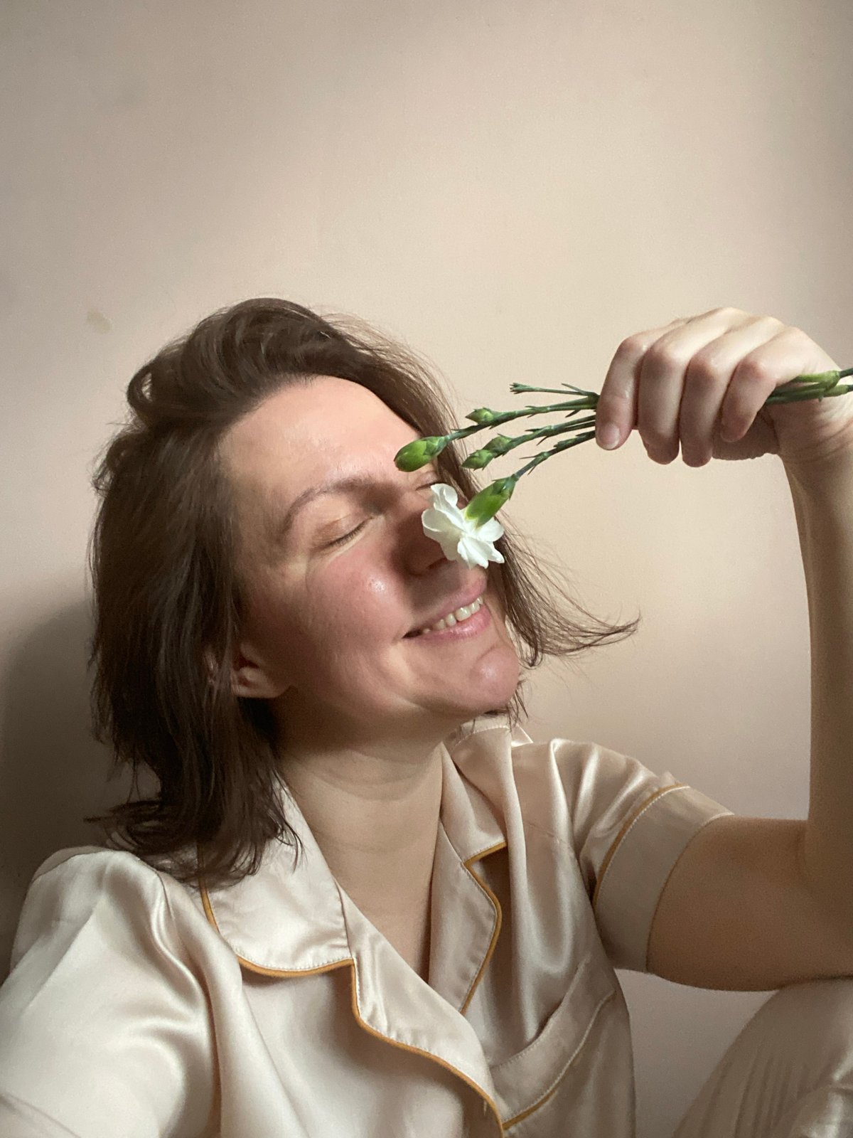 Woman photographs herself with white flowers in Chaikovsky