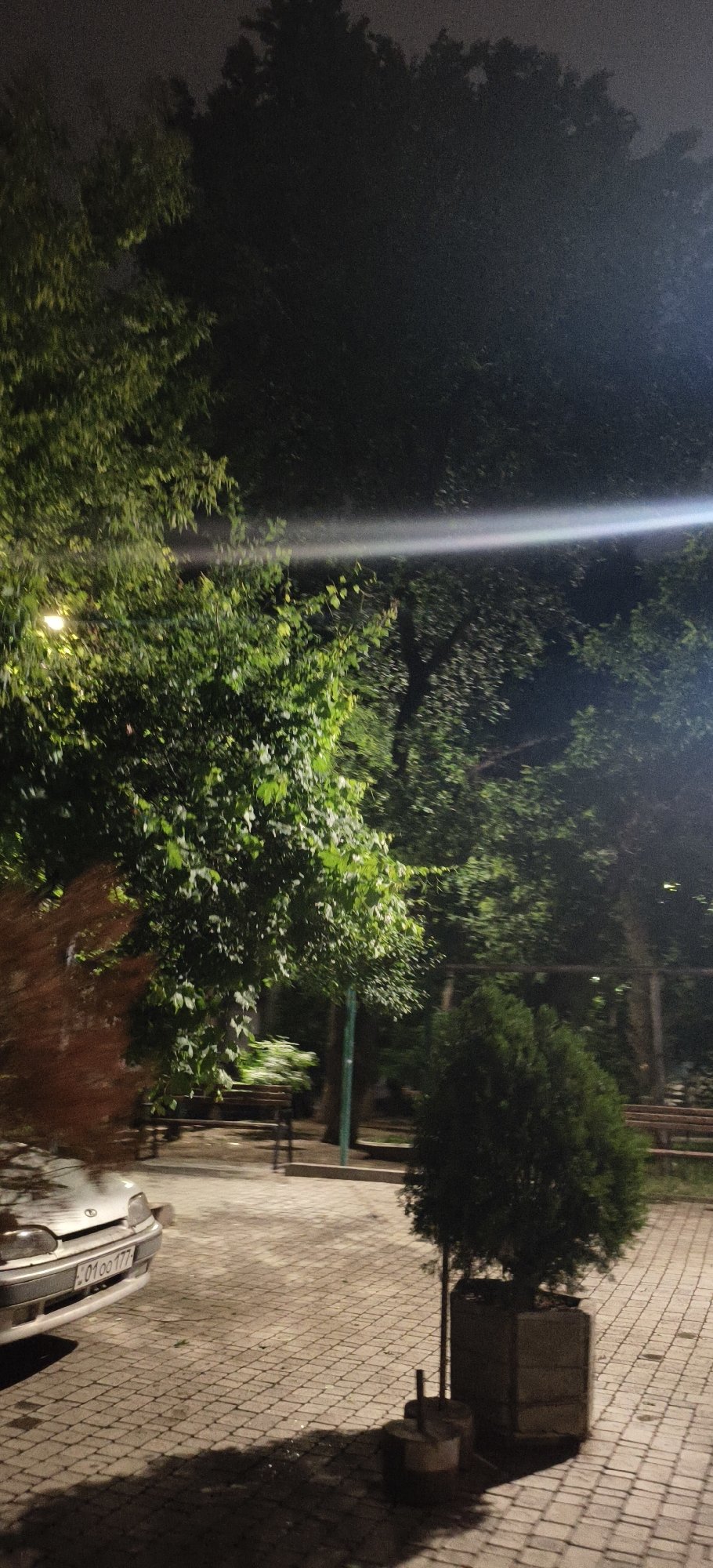 Nighttime urban street scenes documented with wet pavement, parked vehicles