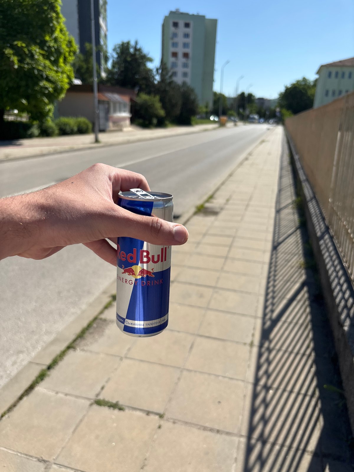 Person holds Red Bull can on Lovech street