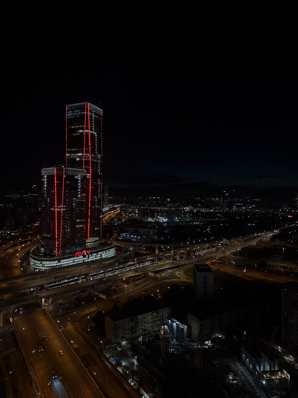 Evening in at a Khimki apartment: gaming, cooking, and neon skyline.