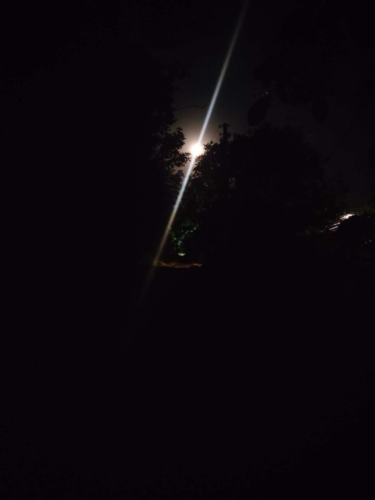 Moonlit night on a rough dirt road with strong light beams