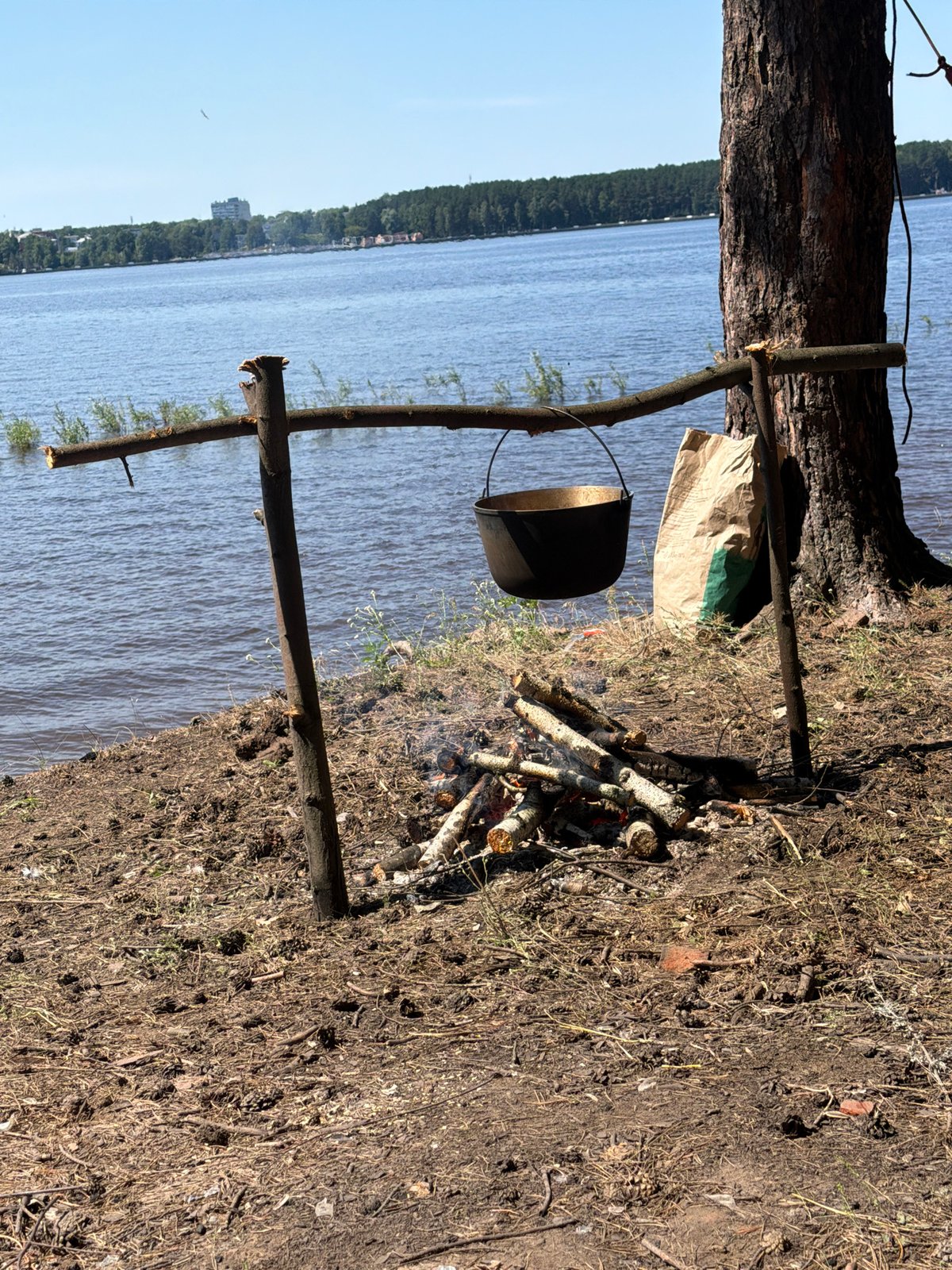 Riverside campfire cooking on a sunny morning in Chaikovsky