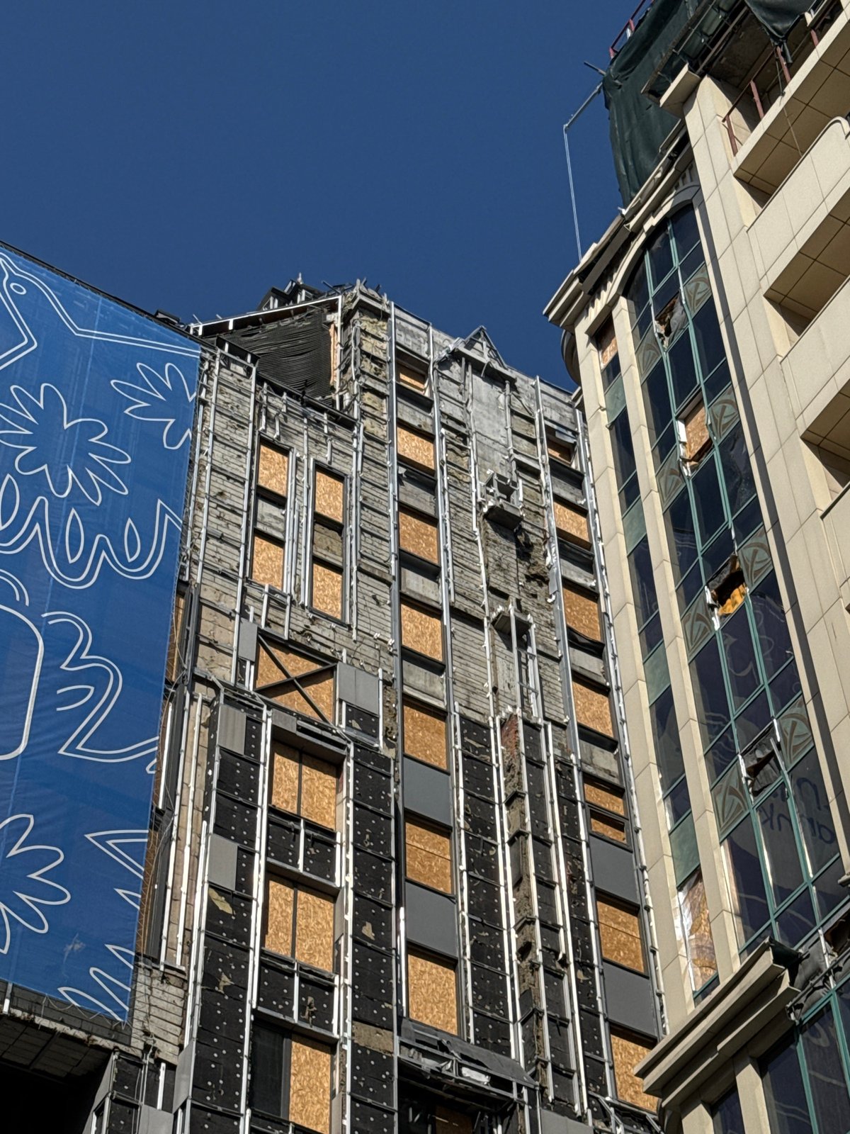 Damaged buildings with boarded windows documented in Kyiv