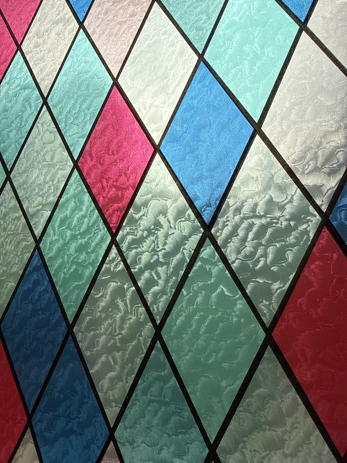 Colorful diamond-paned stained glass window observed in Sofia