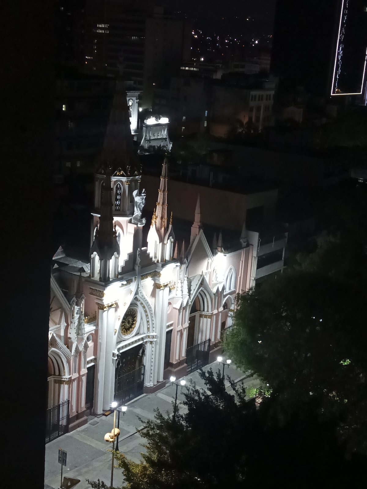 Nighttime documentation captures illuminated church and Caracas cityscape