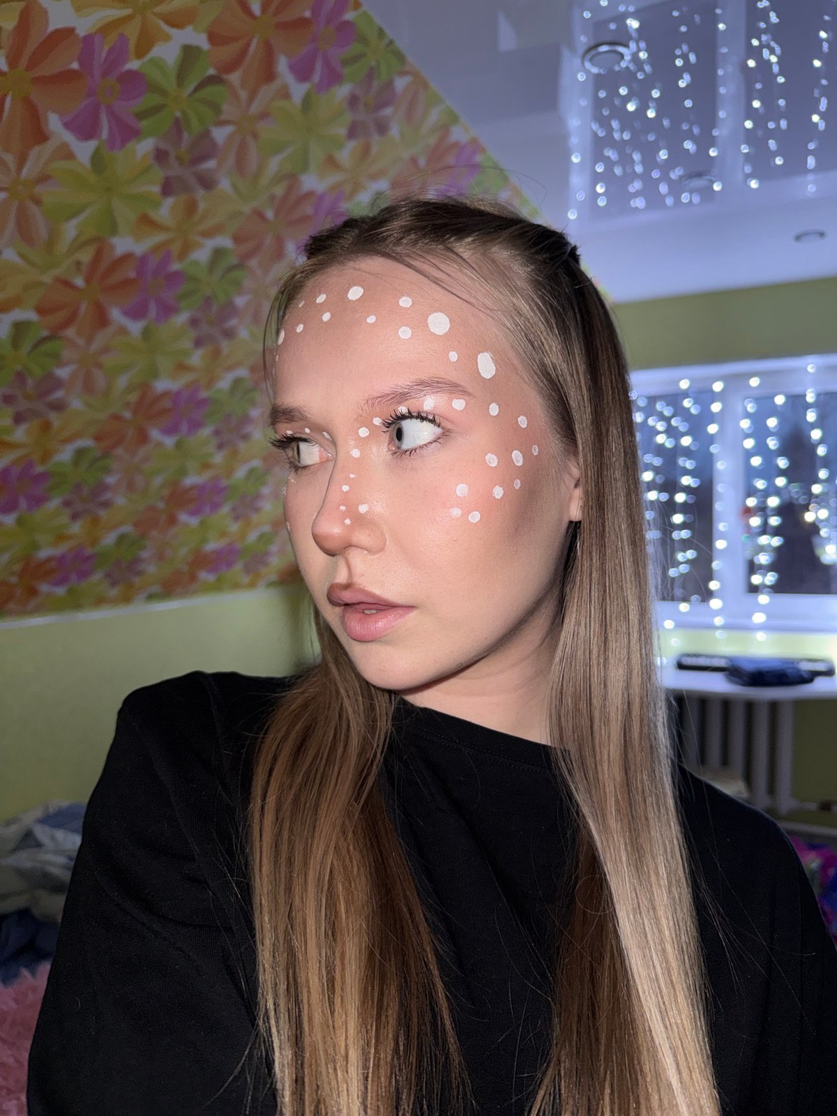 Woman poses with painted white dots on face in Zhigalki