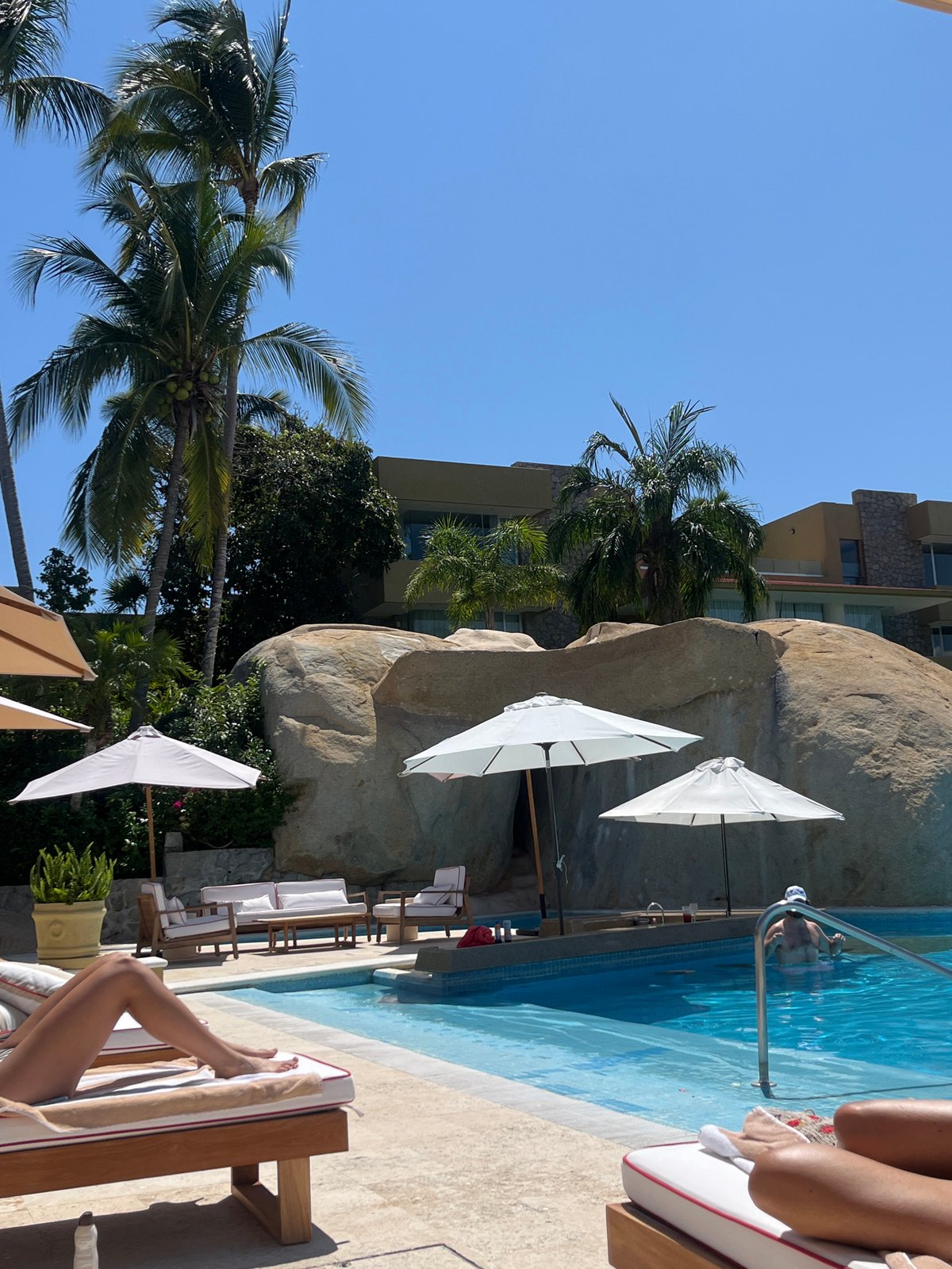 Resort guests relax poolside with drinks in Acapulco
