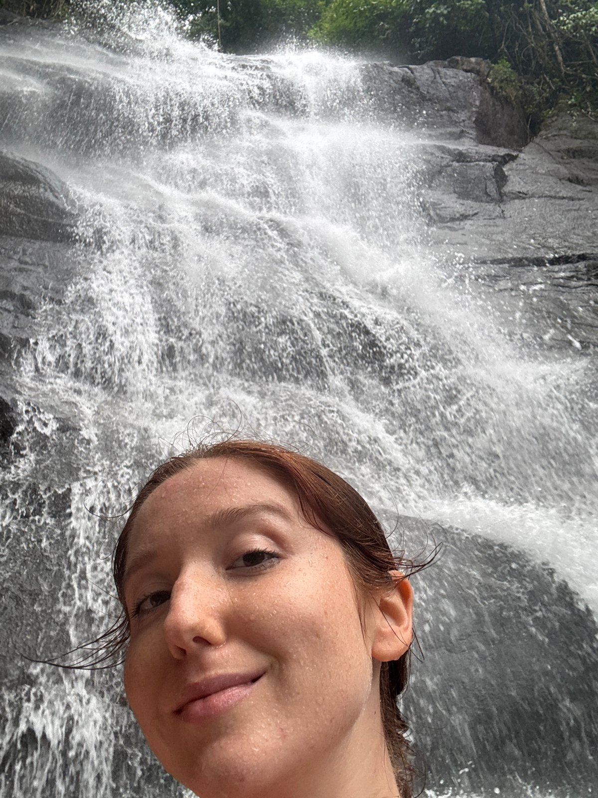 Person enjoys waterfall swim in Ban Bang Khli, Thailand