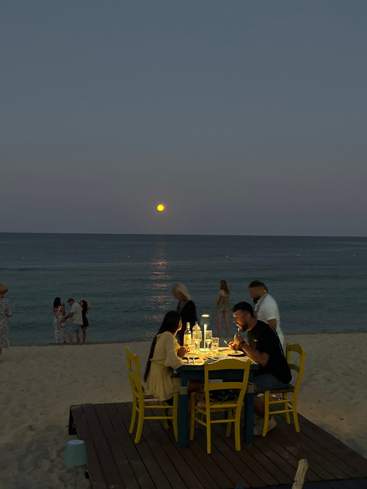 Full moon rising over a beachside dinner in Toroni
