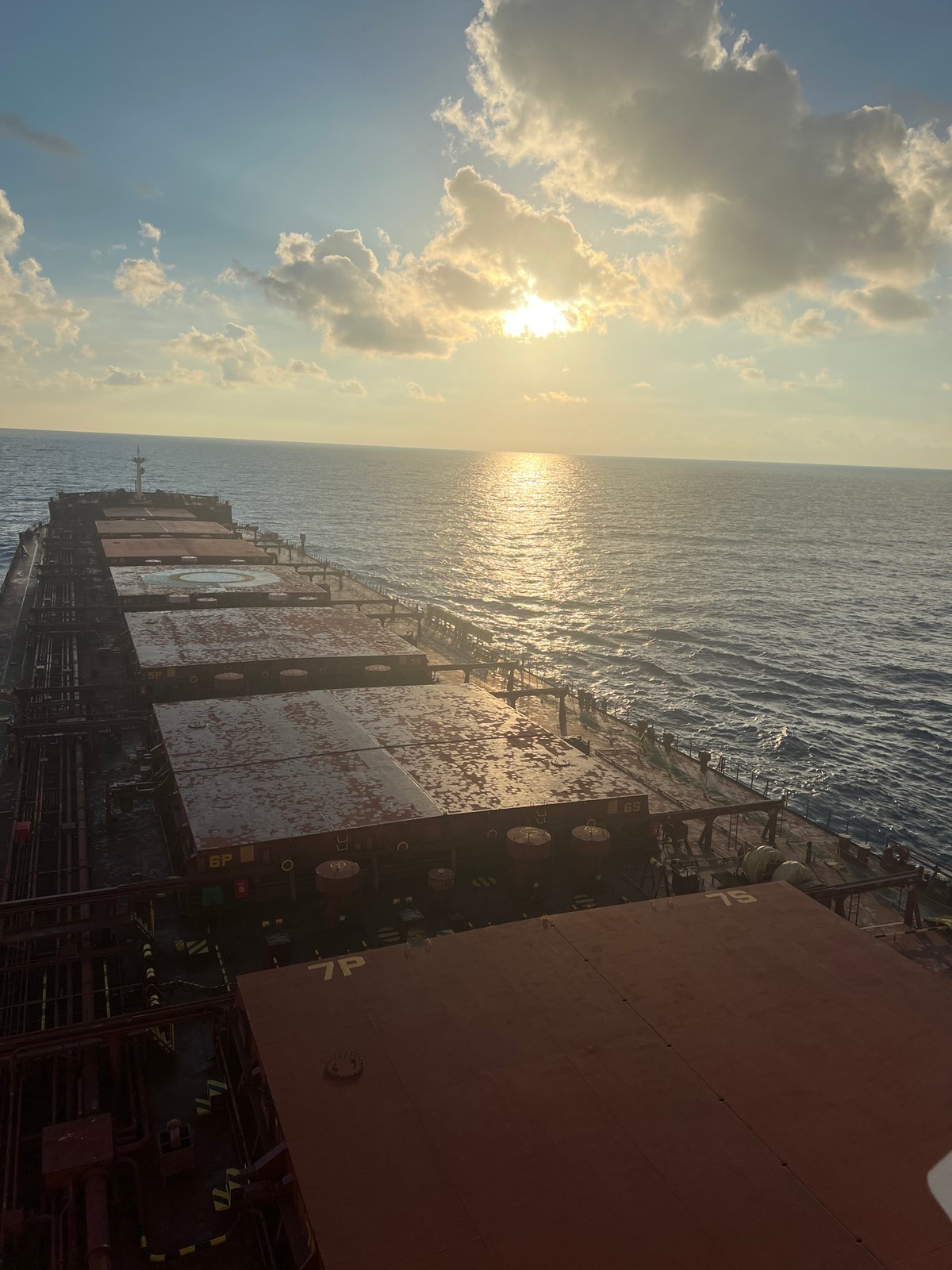 Cargo ship at sea, South China Sea, sunset.