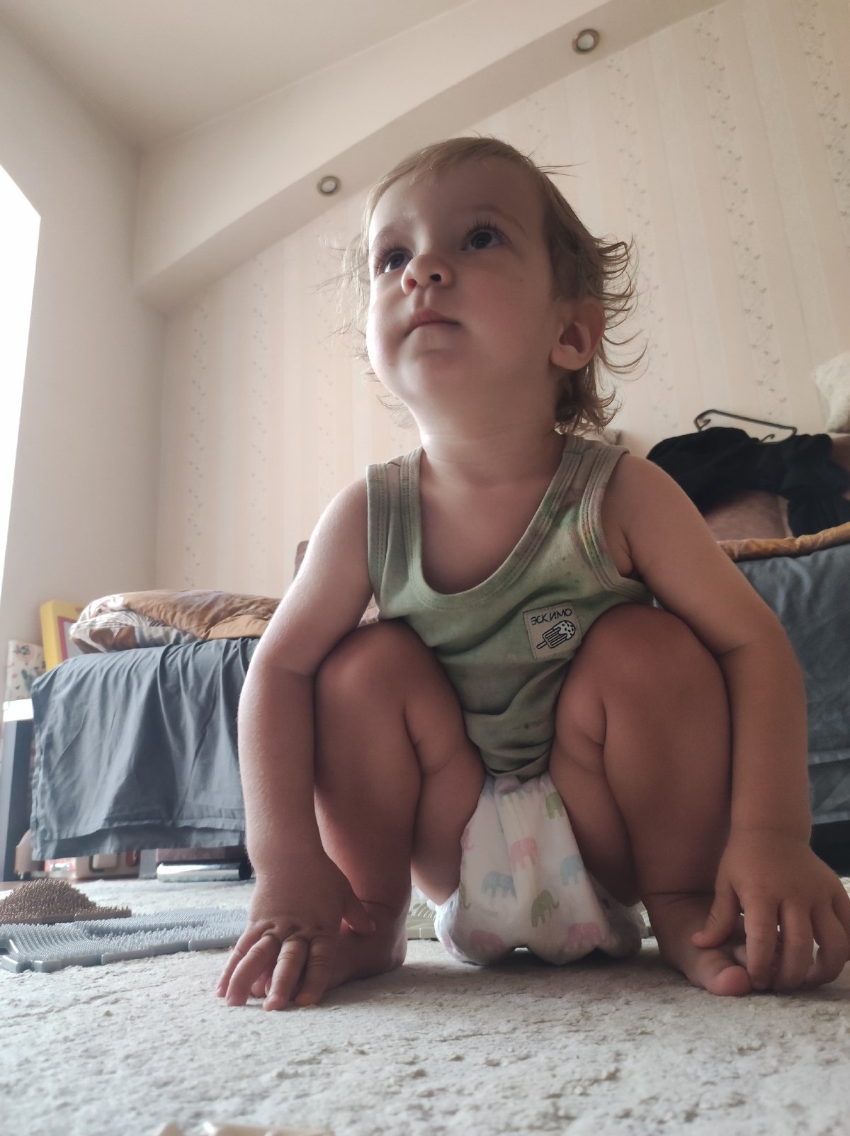 Toddler and poodle share a casual bedroom moment in Russia