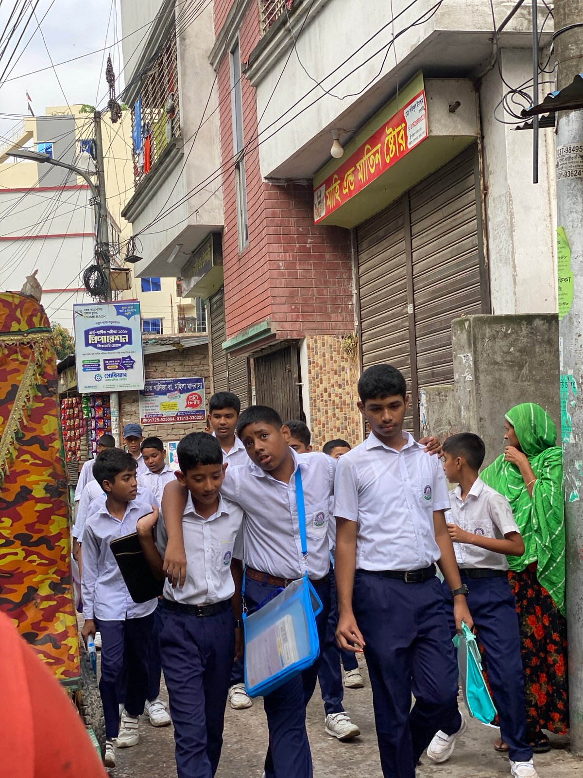 Dhaka streets flooded and busy on a rainy July morning