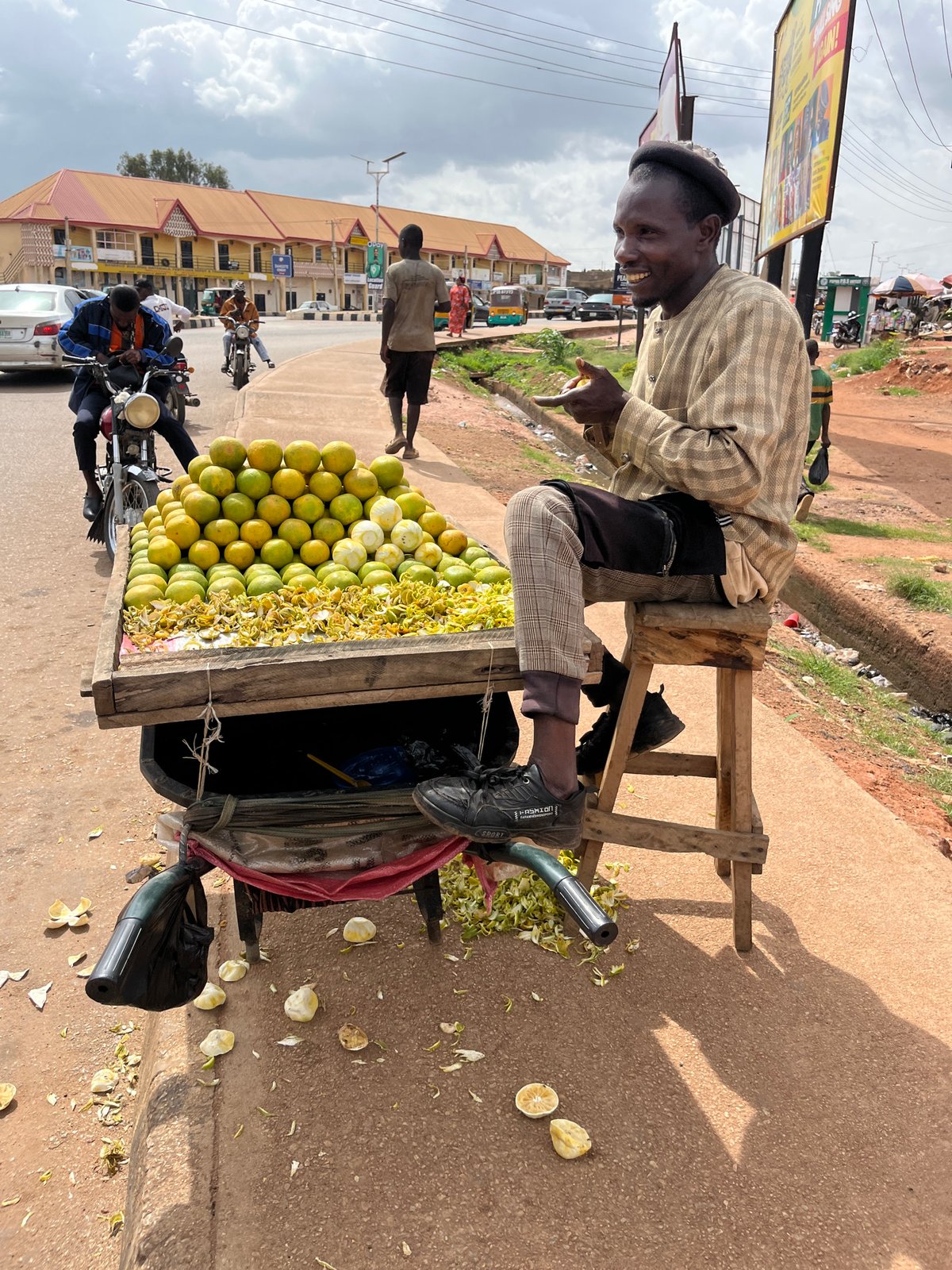 Midday street life in Gura Top: vendors, rickshaws, and a touring motorcycle