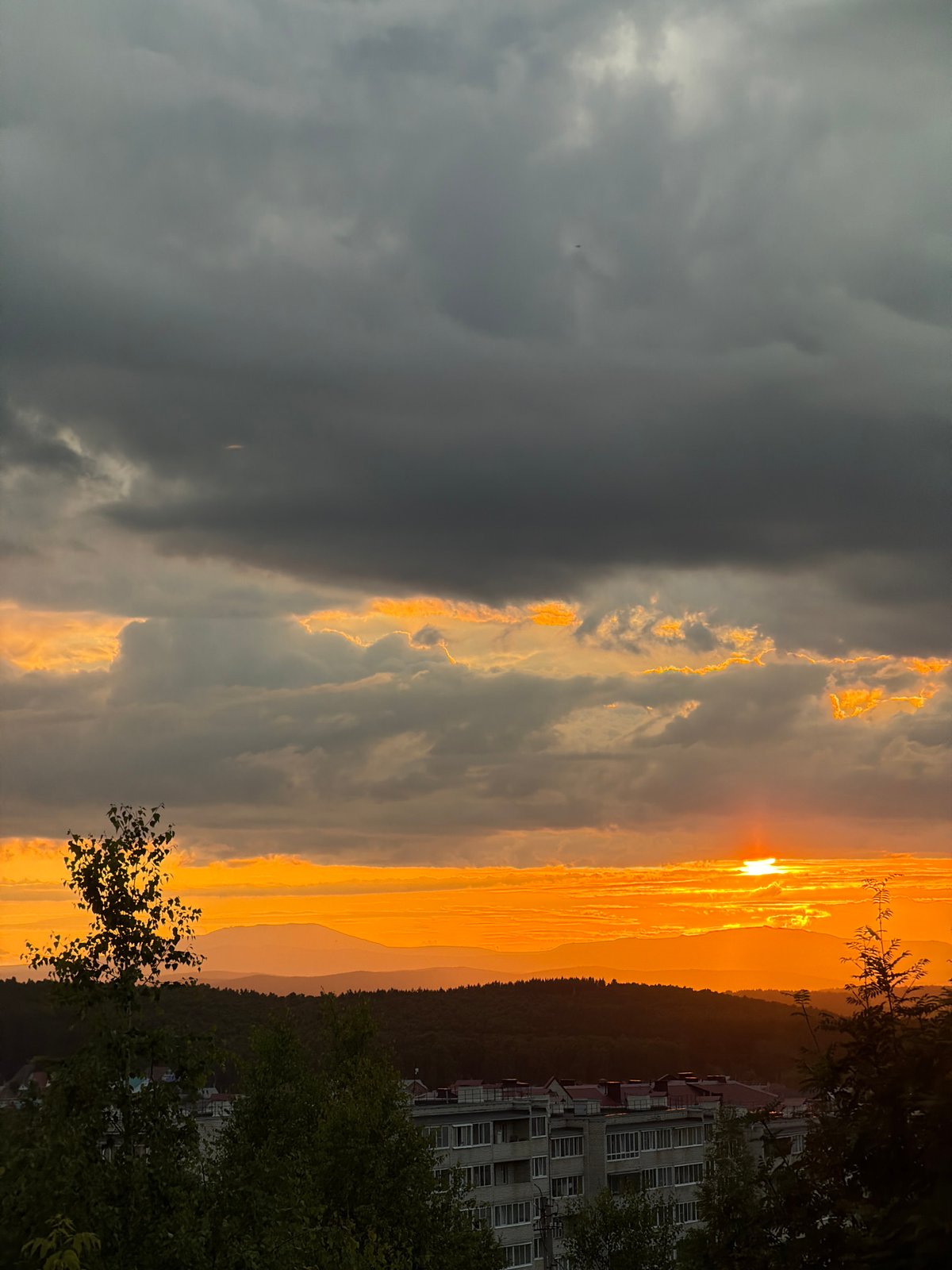 Dramatic sunset over a hilly city, caught from multiple angles