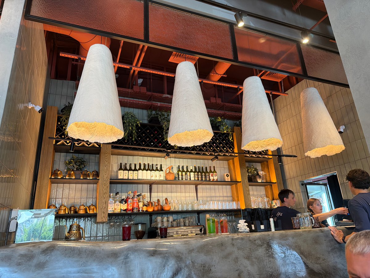 Inside a Tyumen bar with cone lights and stocked shelves
