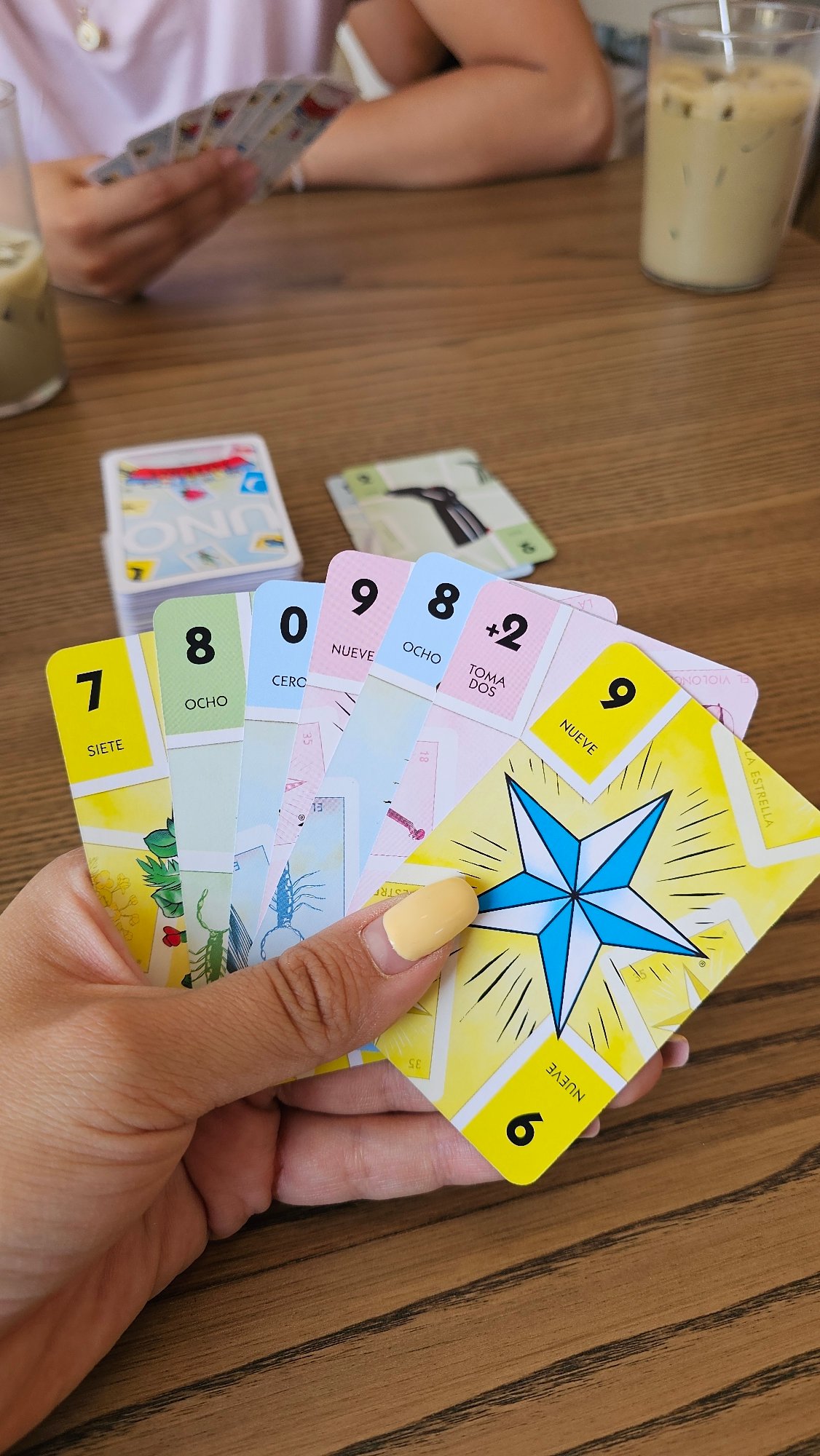 Friends play UNO Lotería at Mexican café with coffee