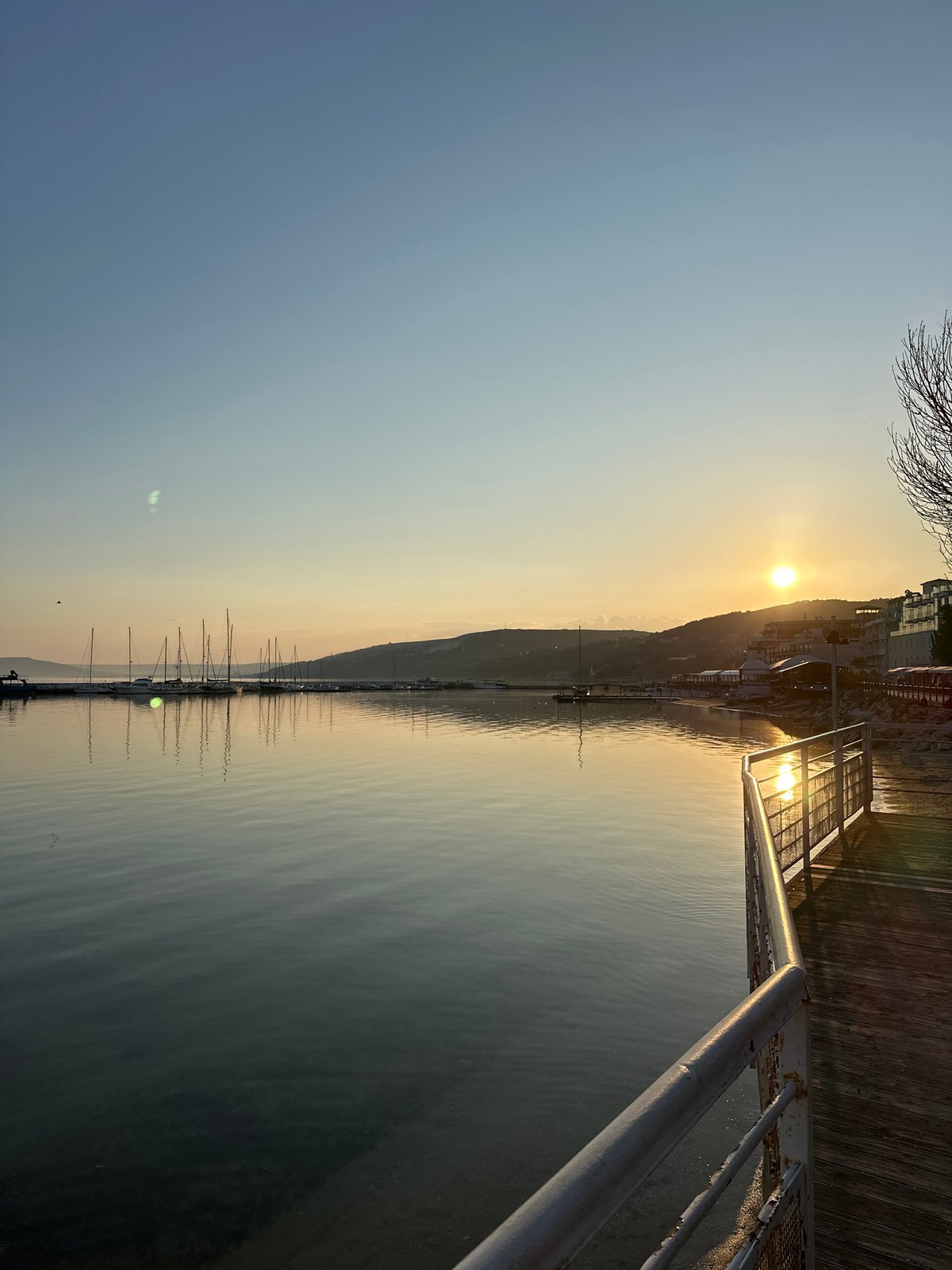 Sunset illuminates Balchik waterfront with moored sailboats
