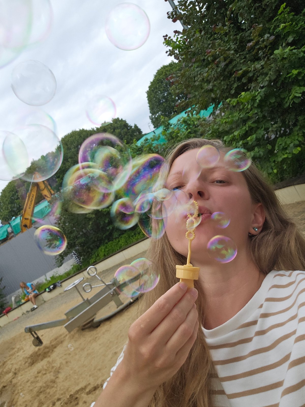Sunny afternoon at a sandy playground — bubbles, kids, good vibes.