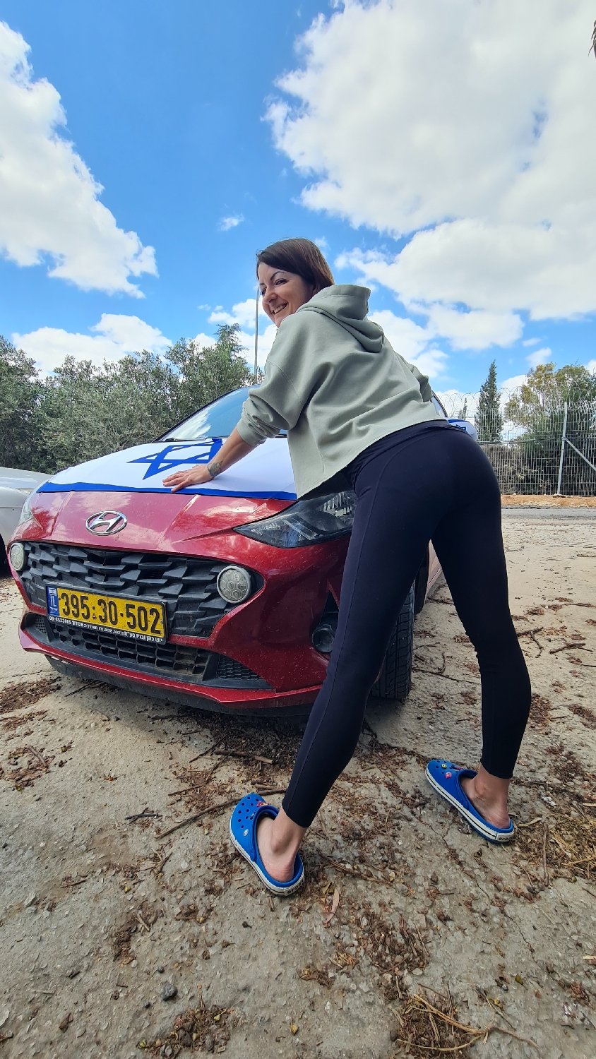 Woman poses with flag-decorated car, aquarium fish photographed