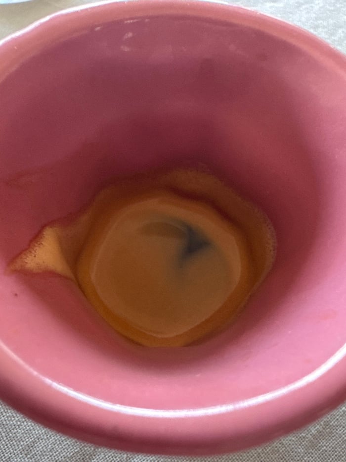 Pink mug with marked brown liquid photographed in London