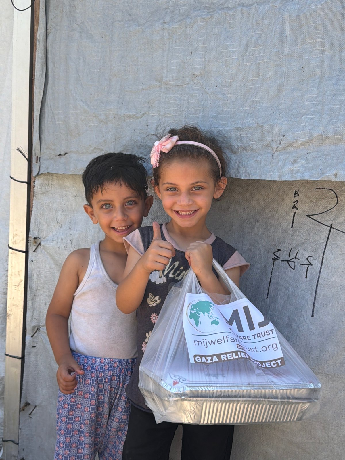 Two children photographed near tarp wall in Gaza